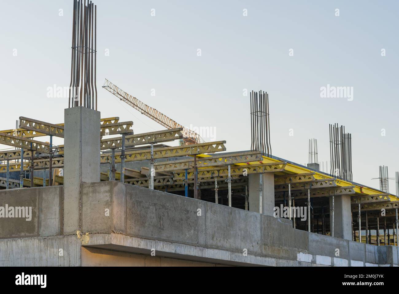 Cantiere con ponteggi monolitici in cemento giallo e grigio. Concetto di costruzione. Foto Stock