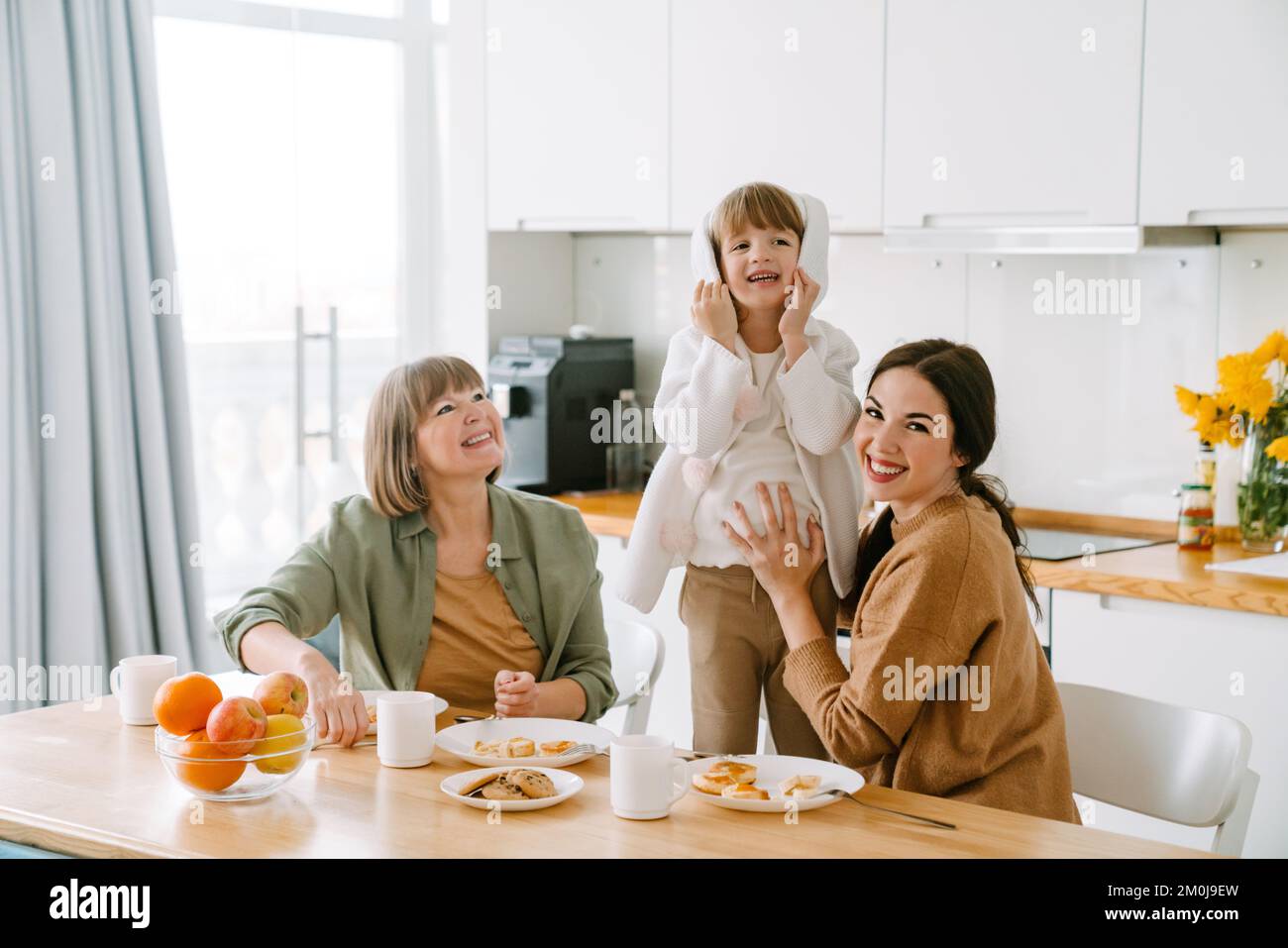 La famiglia bianca fa il divertimento che fa colazione insieme a casa Foto Stock