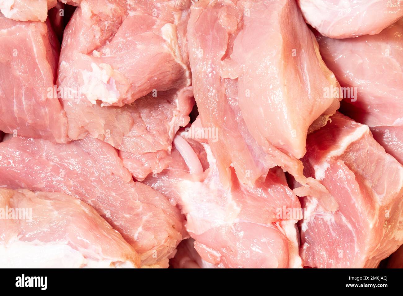 Struttura di carne cruda come sfondo. Primo piano di carne cruda per stufato. Foto macro. Carne cruda - maiale. Foto Stock