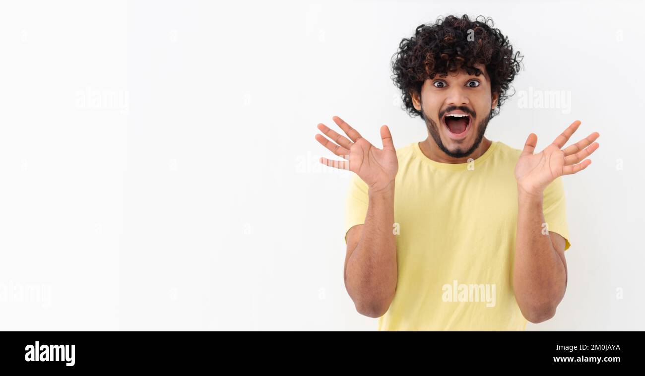 Giovane uomo asiatico con capelli ricci hanno buon umore sentire felice emozione eccitato su uno sfondo bianco copia spazio Foto Stock