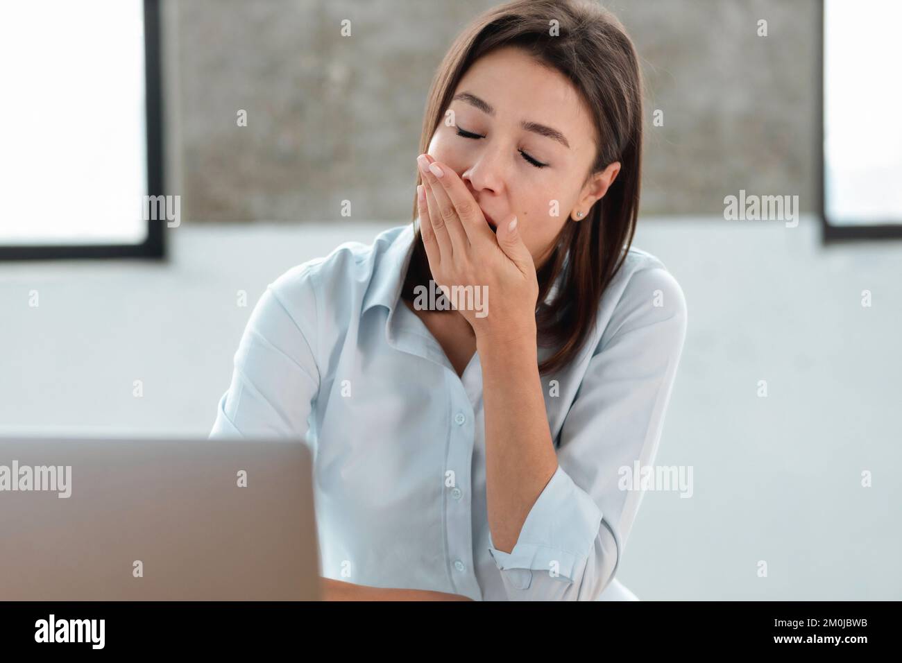 Donna ufficio lavoratore yawns copre bocca sonno cronico privazione overwork concetto Foto Stock