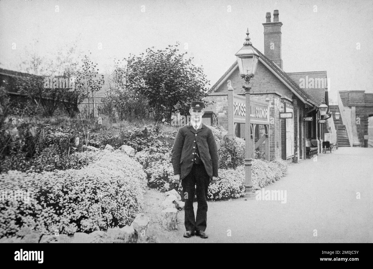 Fotografia dei primi anni del 20th° secolo che mostra la stazione ferroviaria di Crosshill e Codnor nel Derbyshire, Inghilterra. Il Maestro di Stazione Harry Freeman in primo piano. Foto Stock