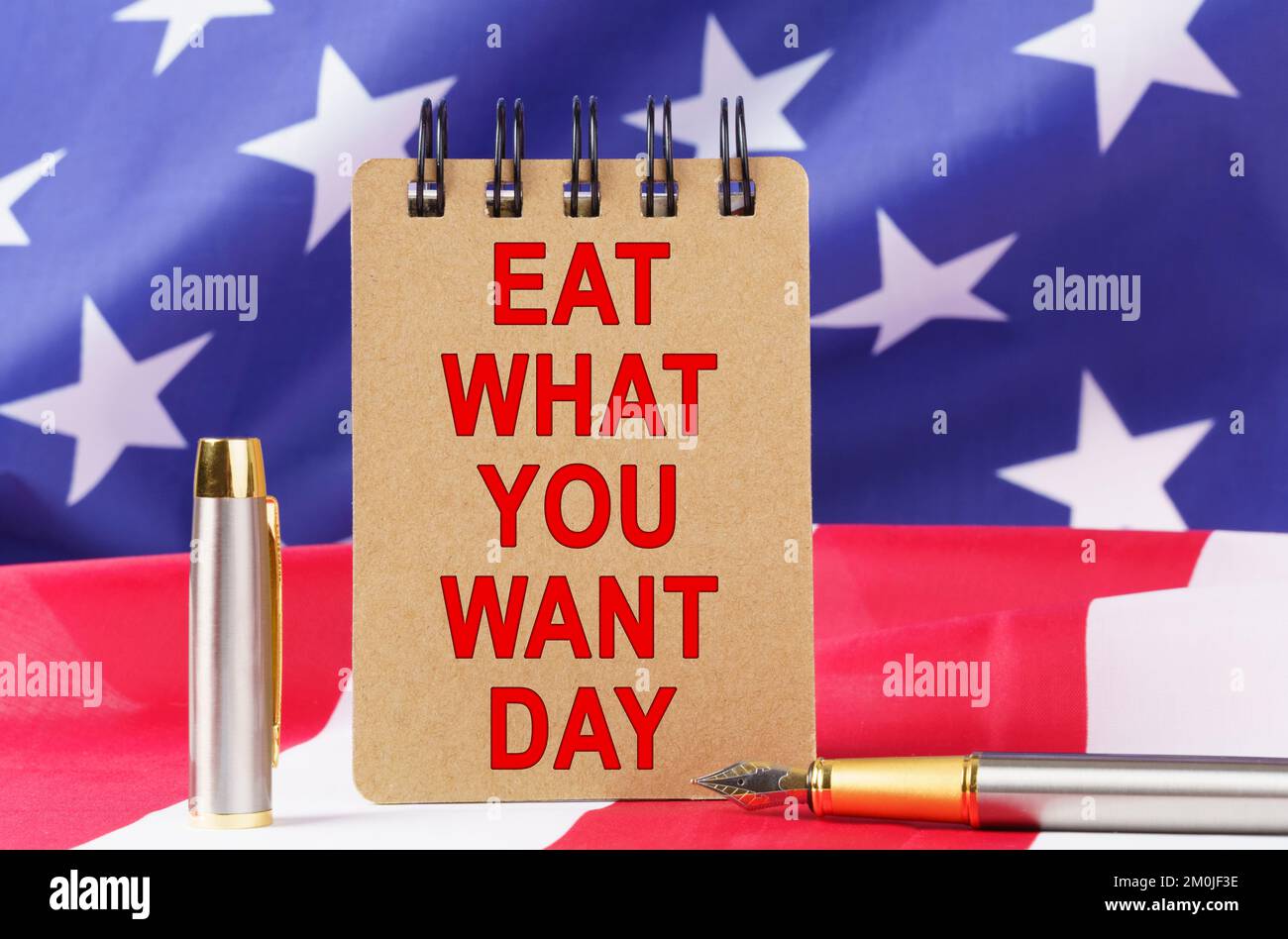 Vacanze USA. Sullo sfondo della bandiera degli Stati Uniti si trova cartone con l'iscrizione - MANGIARE QUELLO CHE SI DESIDERA GIORNO Foto Stock