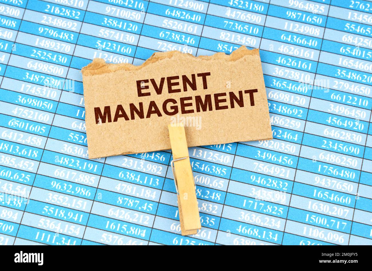 Concetto di business e finanza. Sulle tabelle finanziarie è presente un cartoncino con l'iscrizione - GESTIONE EVENTI Foto Stock
