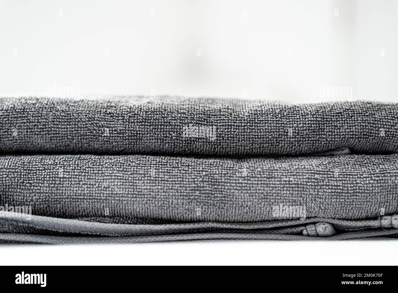 Primi piani degli asciugamani grigi su sfondo bianco Foto Stock