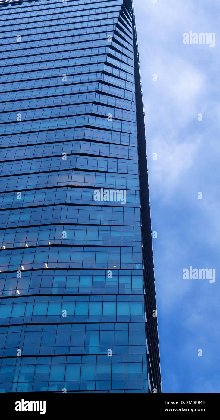 vista parziale di un edificio alto e moderno e di un cielo nuvoloso Foto Stock