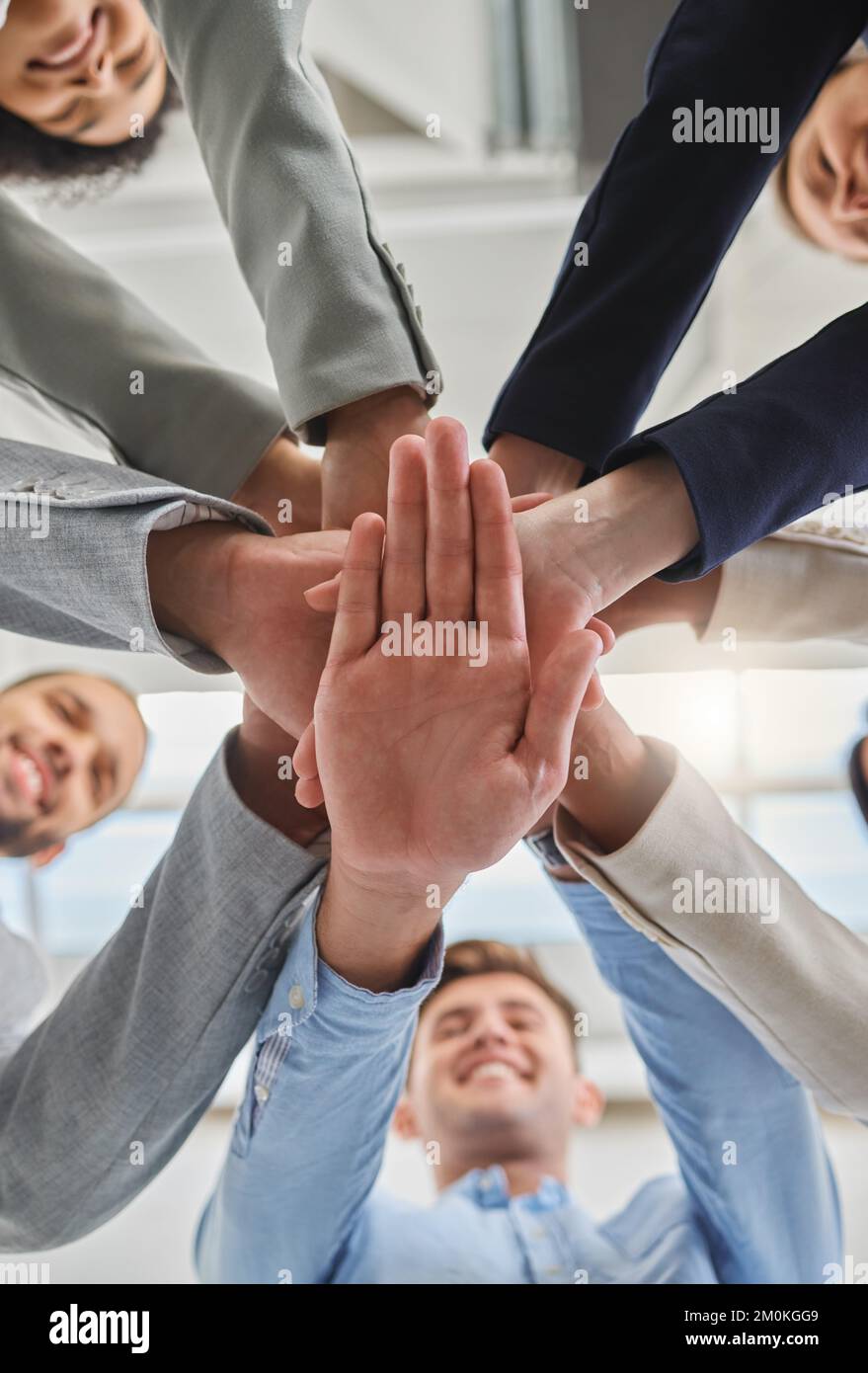 Gruppo di uomini d'affari che impilano le mani in un ufficio sul lavoro. Professionisti di affari che hanno divertimento levarsi in piedi con le loro mani accatastate dentro Foto Stock
