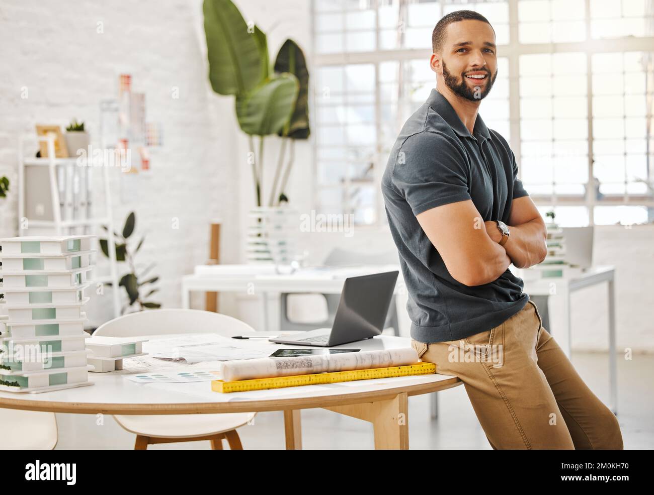 Giovane imprenditore nel suo ufficio di design. Buon architetto nella sua agenzia di design. Imprenditore creativo in piedi nel suo ufficio. Orgoglioso, sicuro Foto Stock