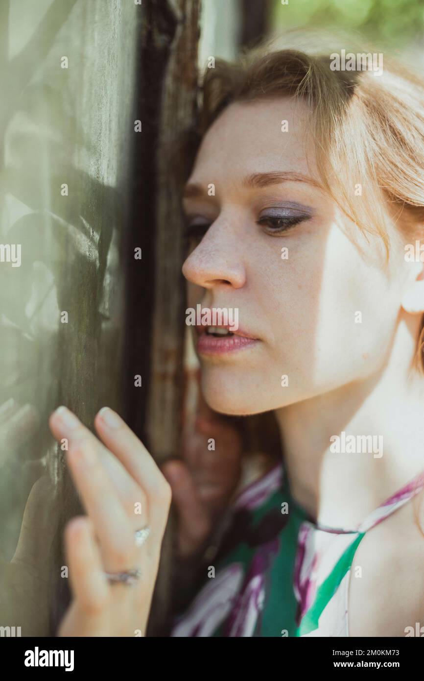 Primo piano bella donna che tocca la finestra fangosa con la punta delle dita ritratto immagine Foto Stock