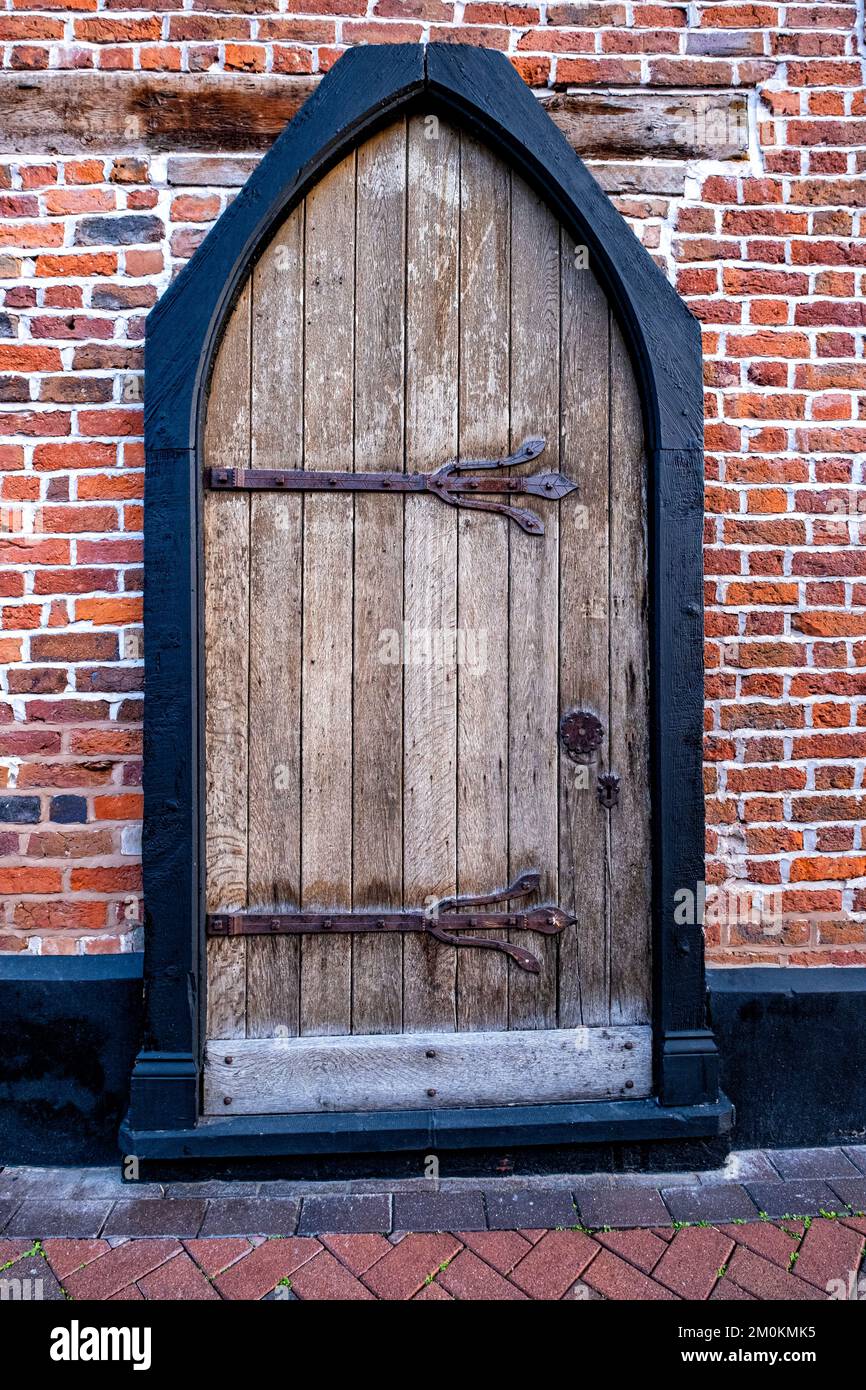Antica porta gotica in legno con grandi cerniere ornate Foto Stock
