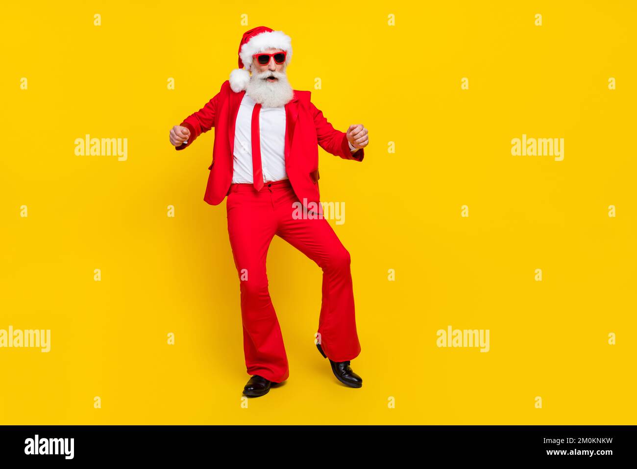 Foto a tutta lunghezza di positivo cute claus indossare pantaloni rosso svasato tux costume avere divertimento ballare discoteca isolato colore giallo sfondo Foto Stock