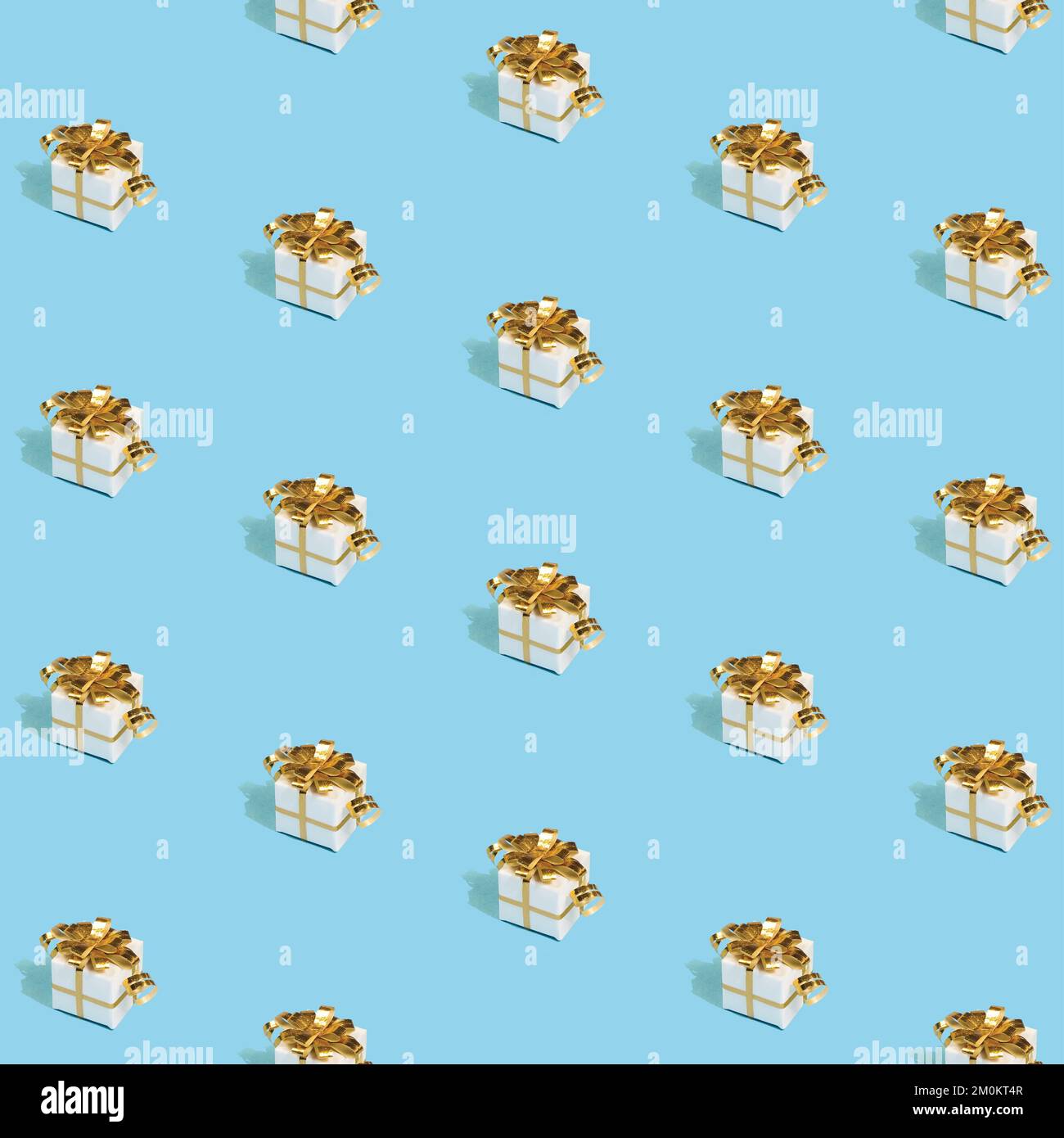 Modello di Natale realizzato con regali di Capodanno con archi dorati su sfondo azzurro luminoso. Concetto di Natale minimo. Foto Stock