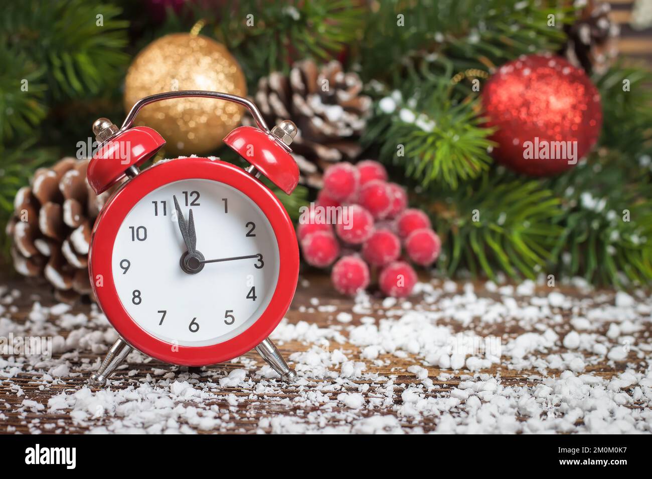 Orologio di Capodanno e ramo di abete rosso rowan, neve, palle e  decorazione su sfondo di legno marrone Foto stock - Alamy