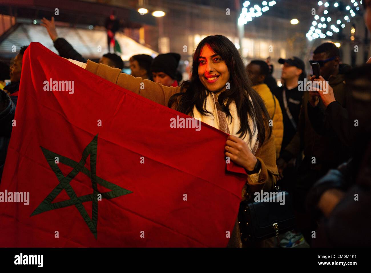 Barcellona, Spagna. 06th Dec, 2022. Una donna marocchina detiene la bandiera marocchina durante le celebrazioni della vittoria della squadra di calcio del Marocco sulla Spagna nel centro della città dopo la partita di calcio. In una vittoria a sorpresa, la squadra marocchina ha battuto la Spagna alle penalità, passando ai quarti di finale, dove affronterà il Portogallo, per la prima volta nella sua storia. Credit: SOPA Images Limited/Alamy Live News Foto Stock
