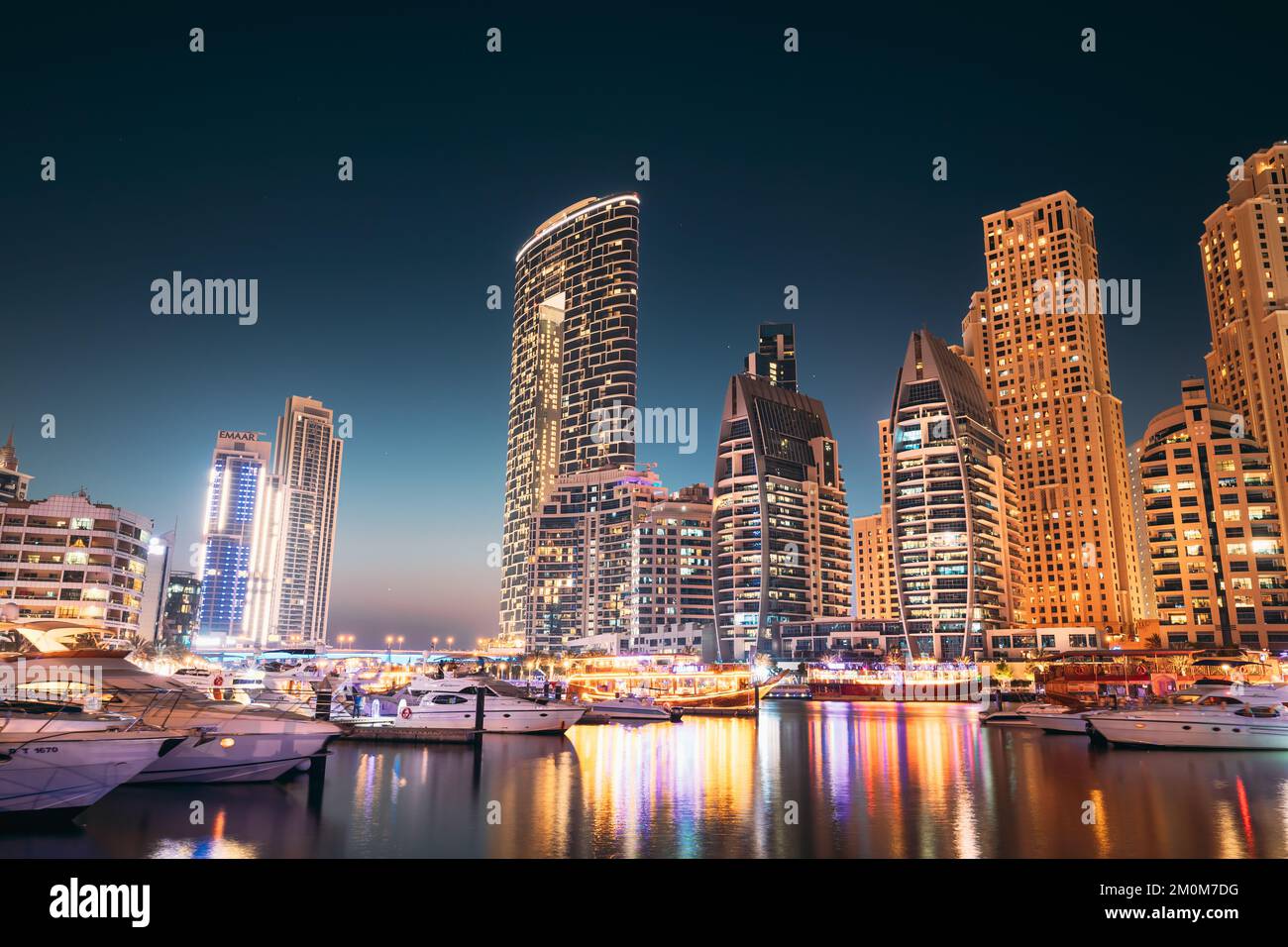 Porto di Dubai Marina, Emirati Arabi Uniti - 19 maggio 2021: Jetty con molti barche ormeggiati, Sightseeing Boat in Evening Night Illuminations. Notte Foto Stock