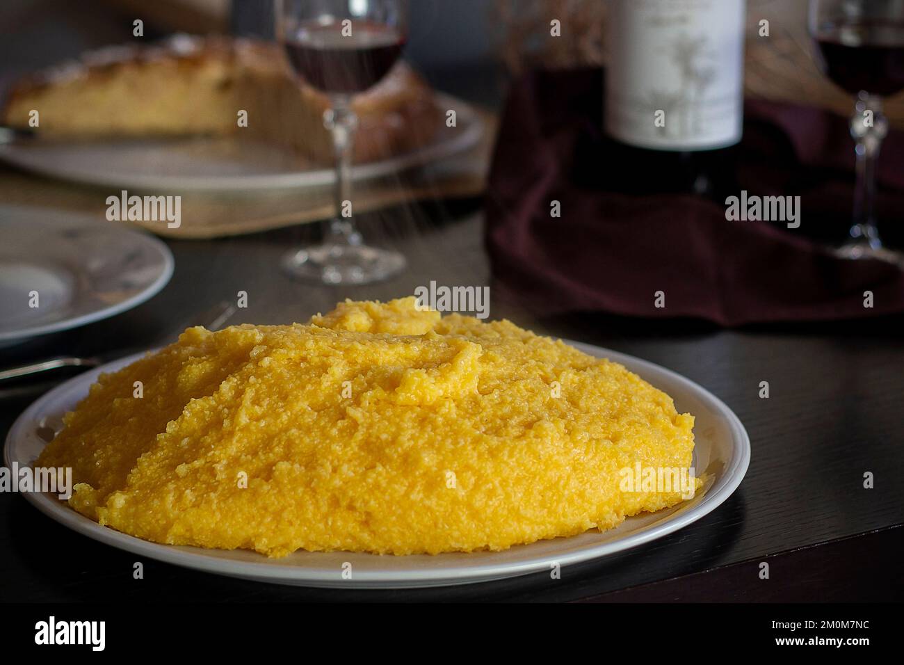 Polenta al tradizionale tavolo da pranzo domenicale. Primo piano Foto Stock