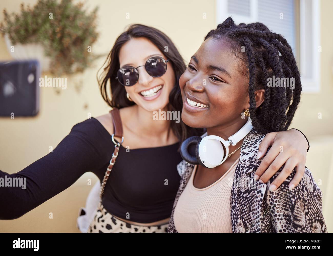 I migliori amici che si divertono e prendono un selfie all'aperto. Due amiche multietniche che trascorrono del tempo insieme e scattano foto per i social media Foto Stock