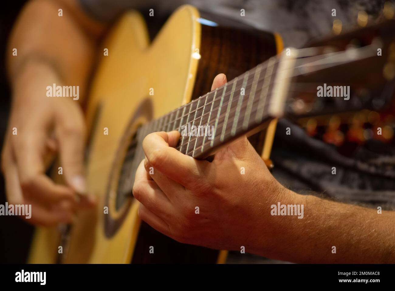 Chiudere fino alle mani di un musicista di suonare la chitarra acustica Foto Stock