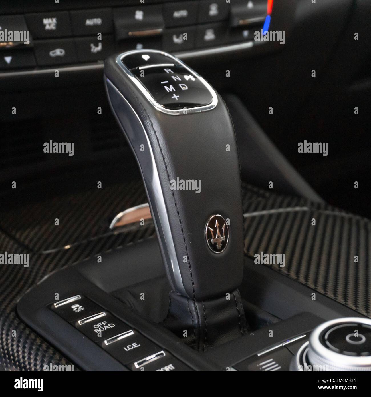 Un primo piano del selettore del cambio Maserati Levante sulla consolle centrale in fibra di carbonio Foto stock