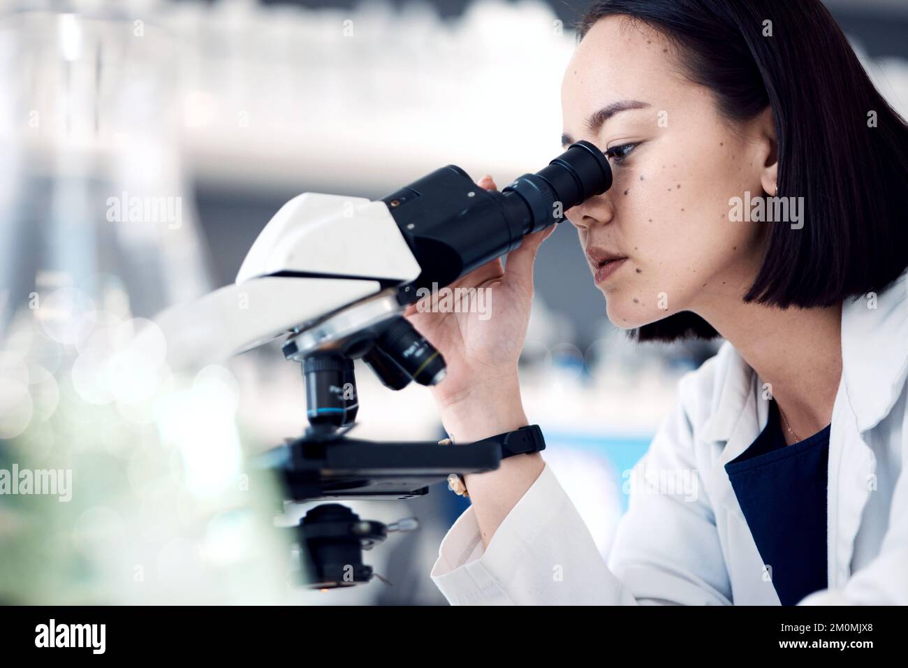 Microscopio, scienziato o donna con ricerca, cura medica o controllare i dati dei campioni in laboratorio. Donna asiatica, ricercatore o dipendente che analizza i risultati Foto Stock