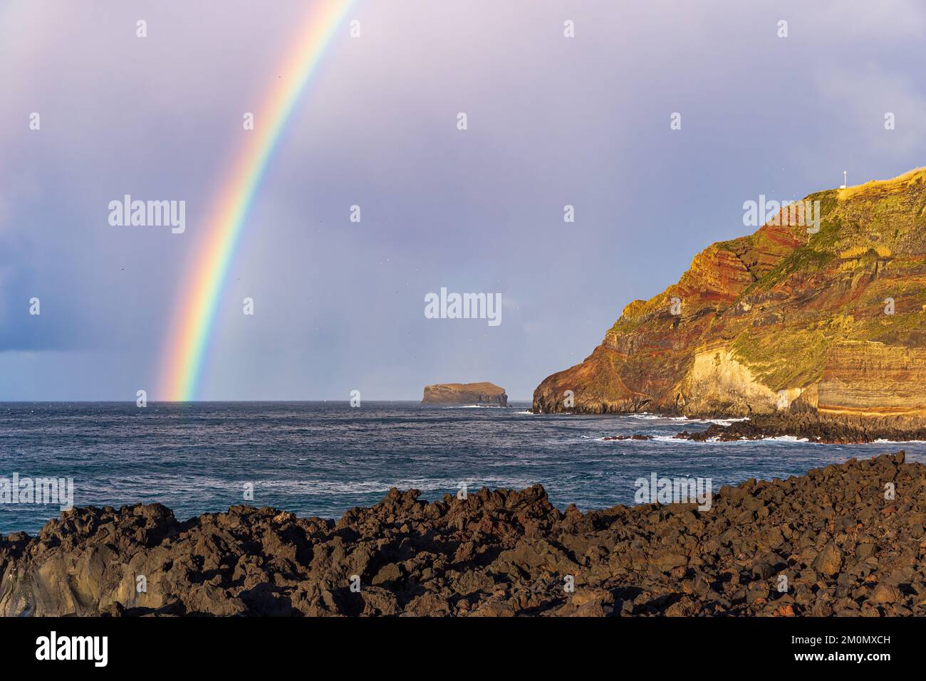 Arcobaleno che si inarcata dall'Oceano Atlantico a Ponta da Ferraria, isola di Sao Miguel, Azzorre, Portogallo Foto Stock