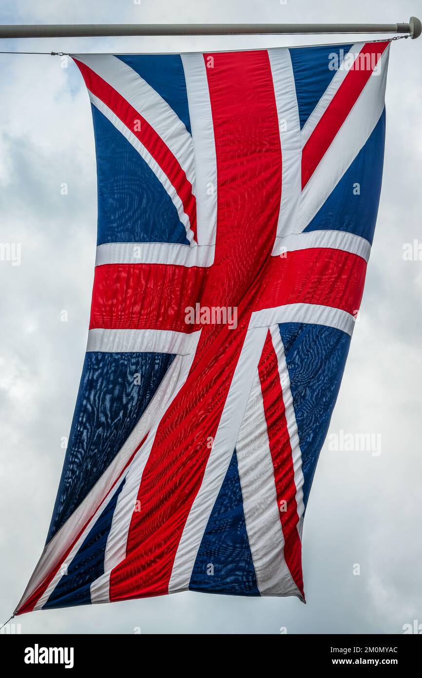 Bandiera britannica su un palo che galleggia nel vento Foto Stock