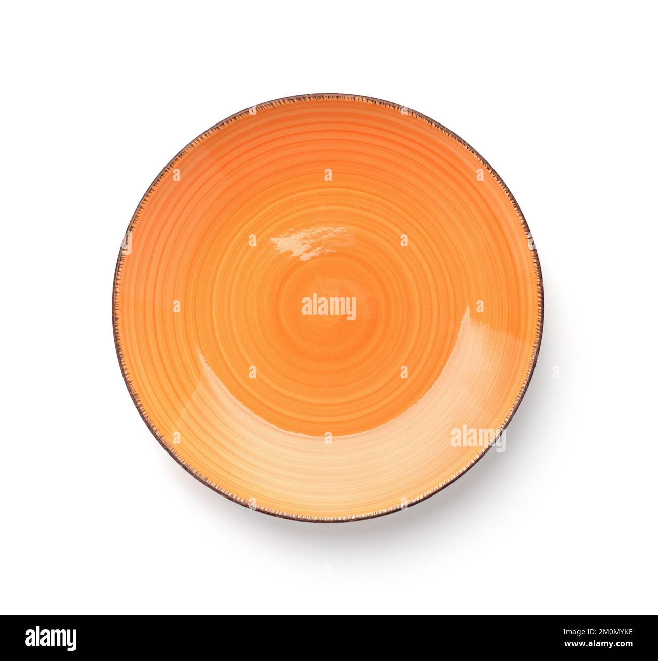 Vista dall'alto della piastra rotonda in ceramica arancione vuota con bordo scuro isolato su bianco Foto Stock