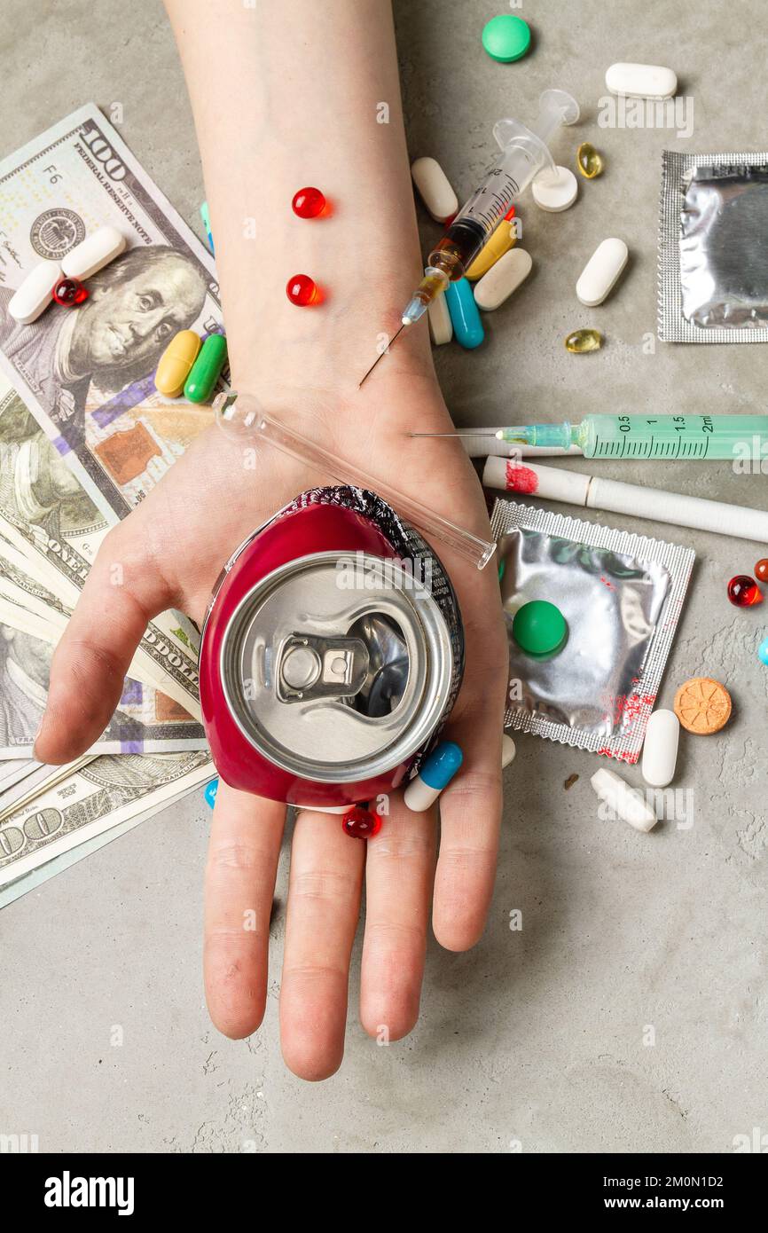 Vista dall'alto mano che tiene una lattina di soda frantumata. Concetto di tossicodipendenza. Foto Stock