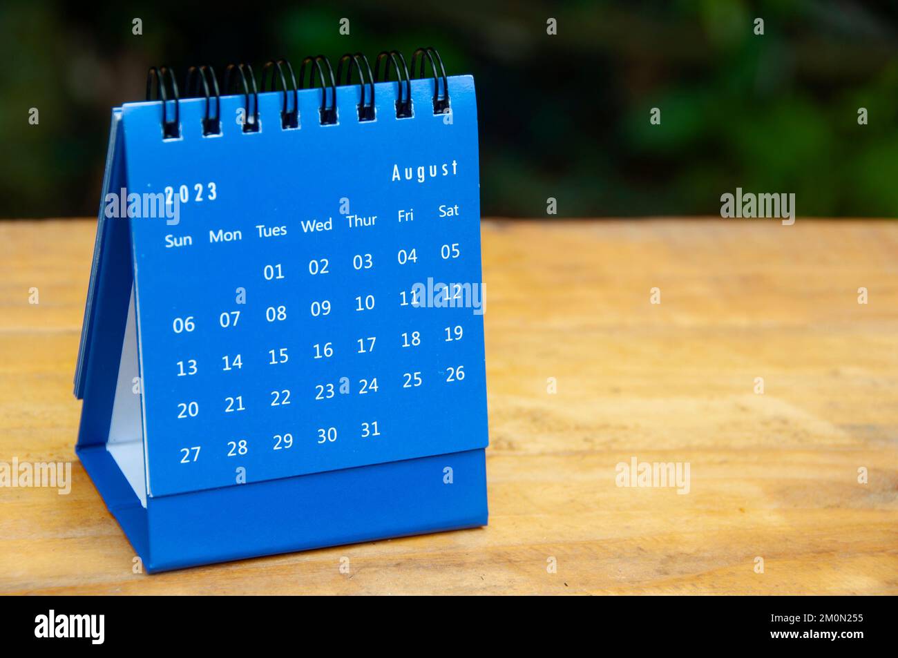 Agosto 2023 calendario da tavolo blu su sfondo tavolo in legno con spazio personalizzabile per il testo. Foto Stock