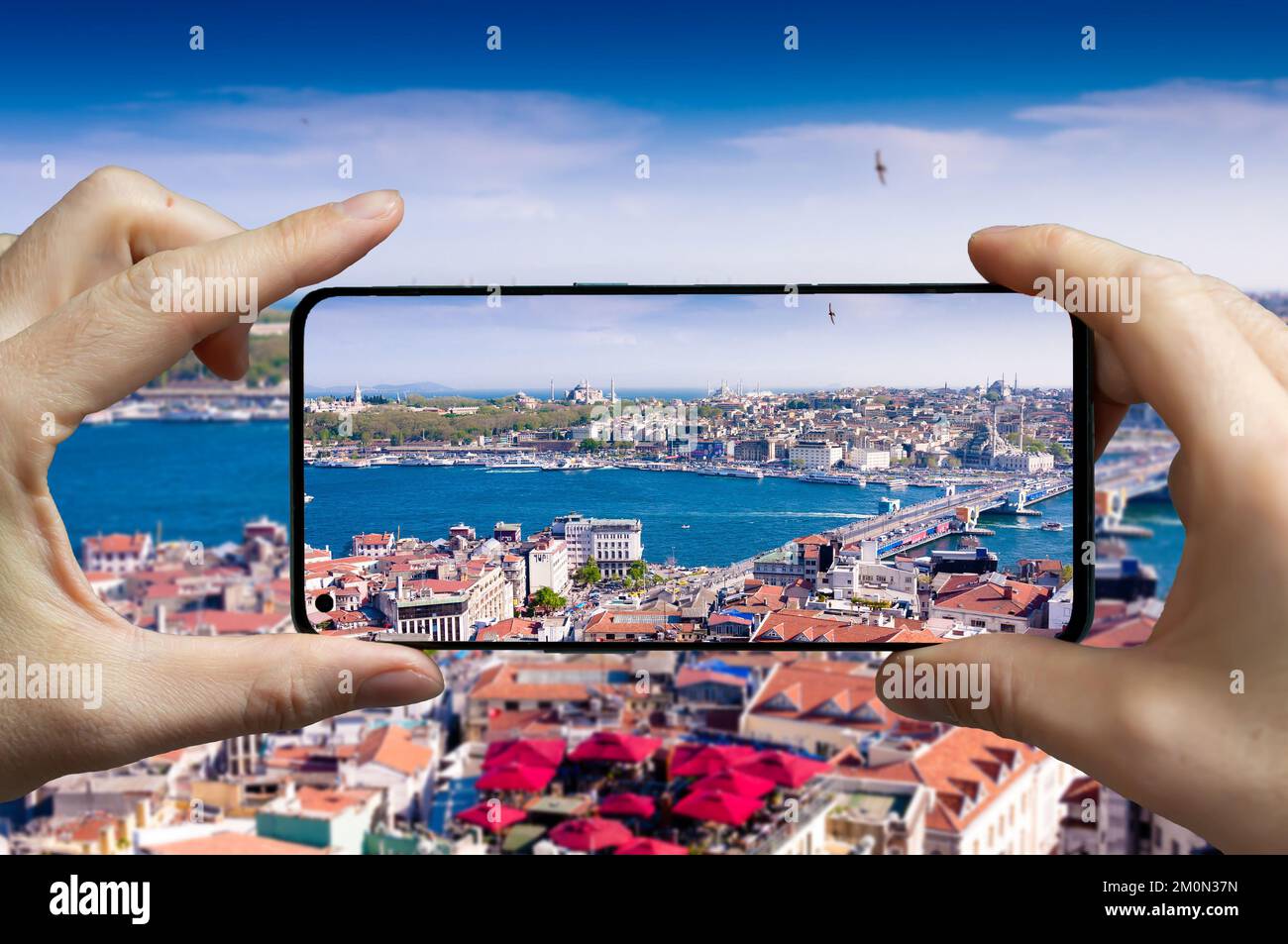 Tourist scattare una foto con un telefono cellulare dalla torre Galata a Istanbul, Turchia. Foto Stock