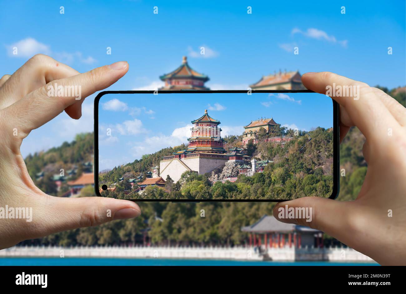 Tourist scattare una foto con un telefono cellulare al palazzo estivo a Pechino, Cina. Foto Stock