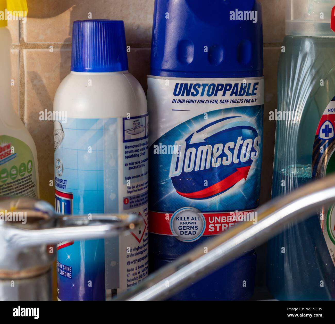 Londra. UK- 12.07.2022. Una bottiglia di candeggina Domestos da un lavello da cucina tra gli altri prodotti per la pulizia della casa. Foto Stock