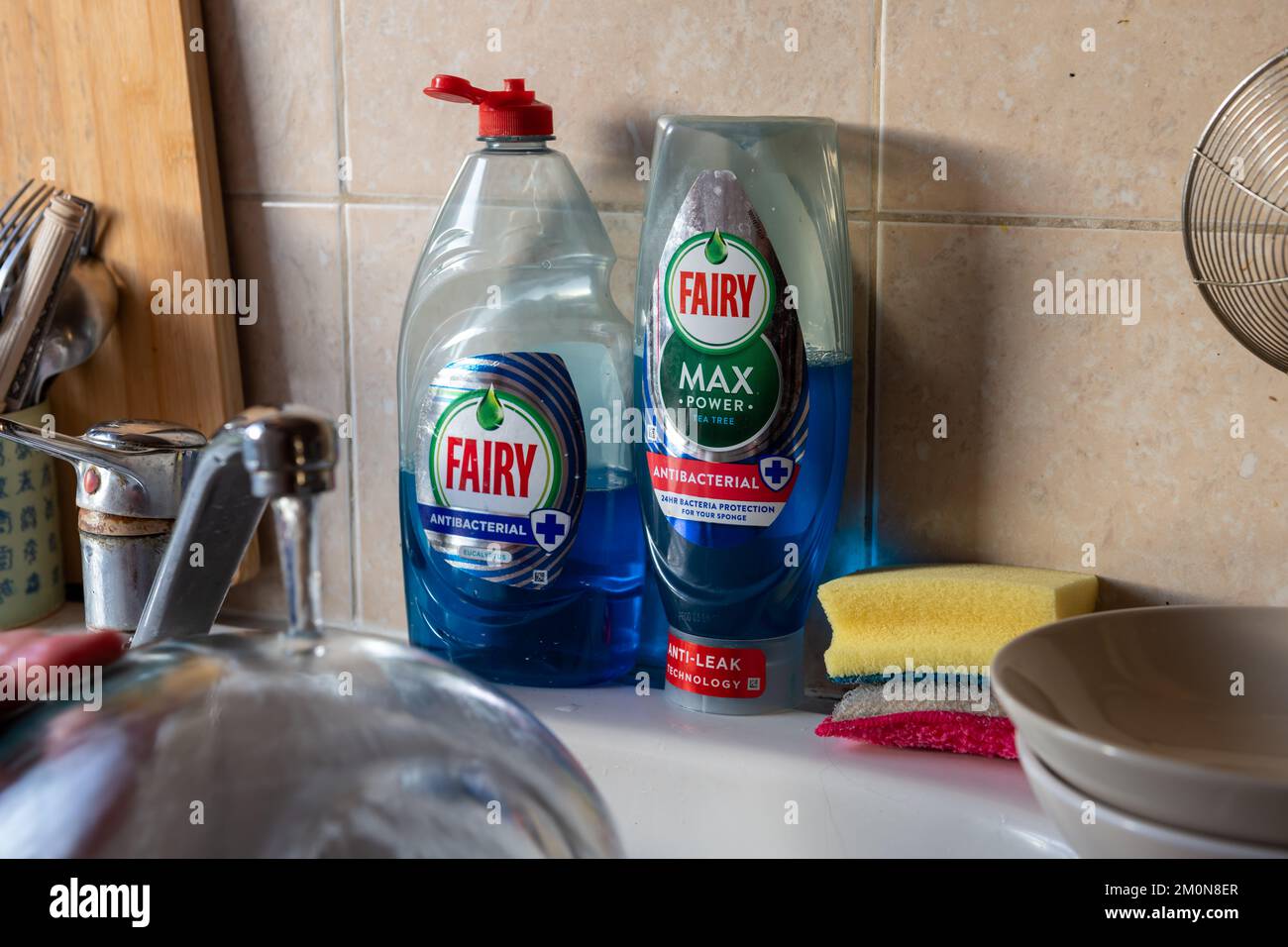 Londra. UK- 12.07.2022. Una bottiglia di Fairy Max e di liquido antibatterico per lavare i piatti da un lavandino da cucina. Foto Stock