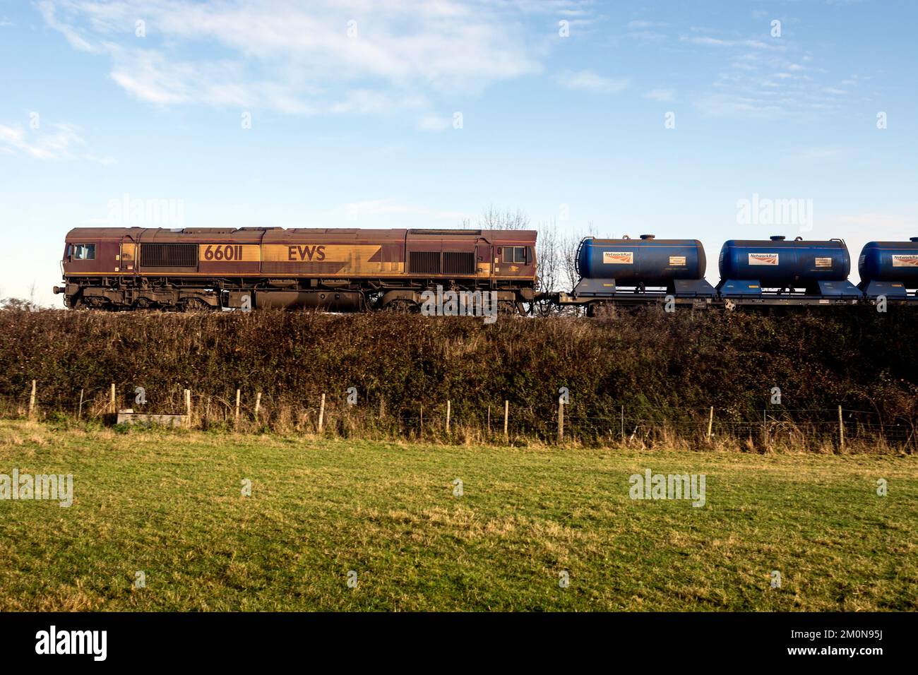 Locomotiva diesel EWS classe 66 n. 66011 diretta a un treno di trattamento della testa ferroviaria (RHTT), Warwickshire, Regno Unito Foto Stock