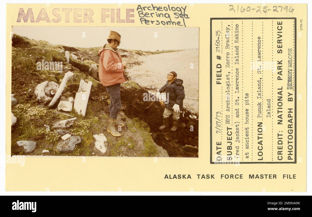 NPS archeologo Zorro Bradley (giacca rossa) e St Lawrence Island Eskimo presso antichi pozzi casa. Alaska Task Force fotografie Foto Stock