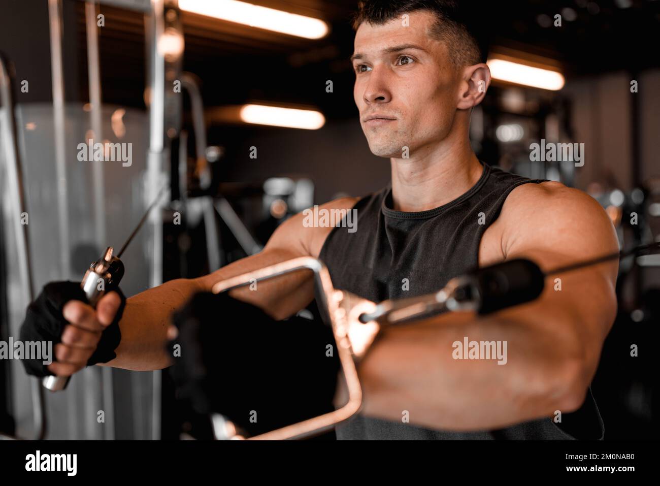 Concetto di palestra con modello maschile e varie attrezzature per l'allenamento Foto Stock