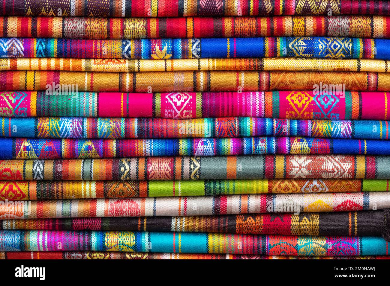 Colori vibranti dei tessuti tradizionali delle Ande sul mercato dell'arte e dell'artigianato, Otavalo, Ecuador. Tessuti trovati in Bolivia, Perù ed Ecuador. Foto Stock