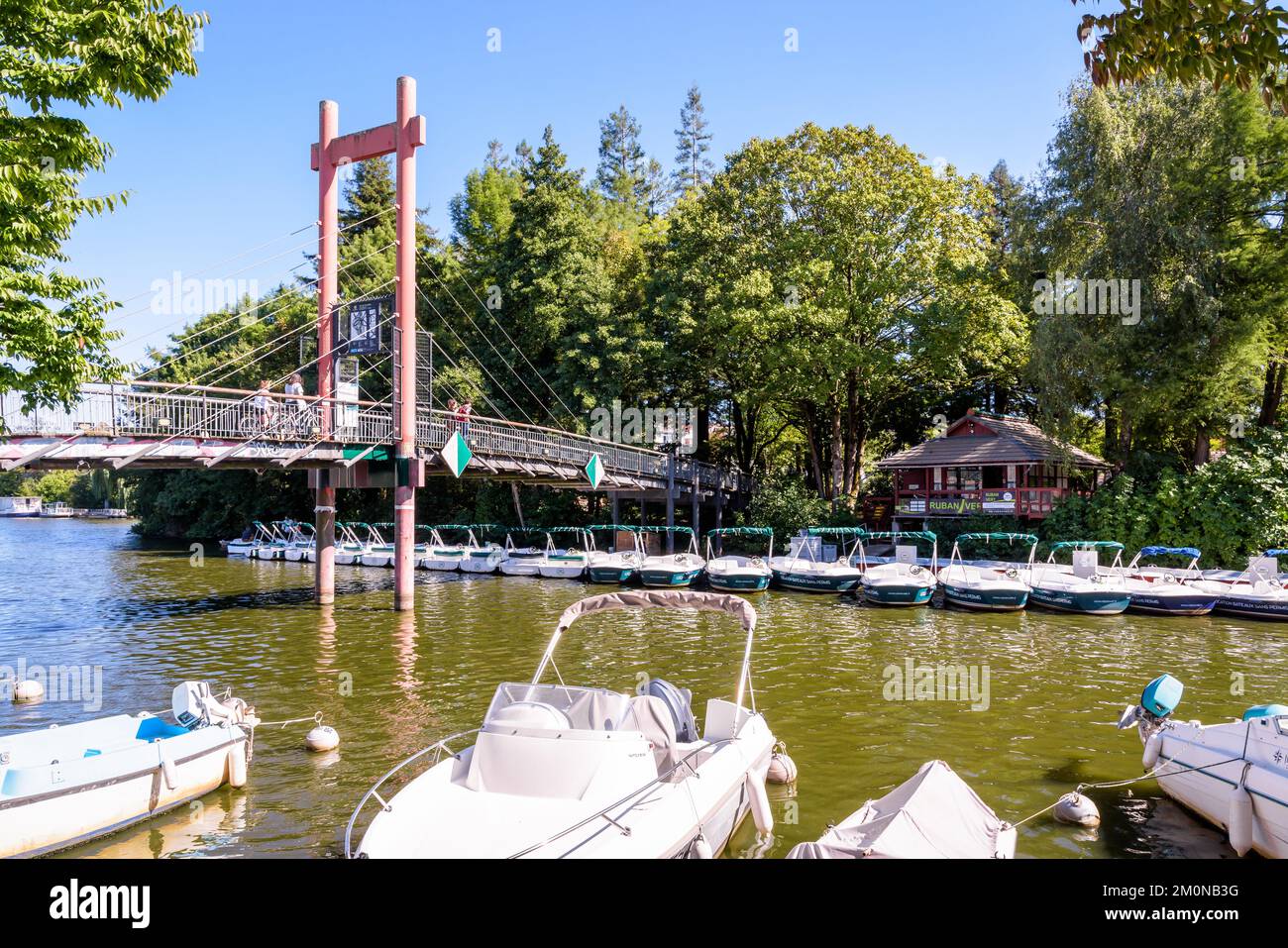 Barche a noleggio elettriche ormeggiate sull'isola di Versailles sul fiume Erdre a Nantes, Francia, ai piedi della passerella in stile giapponese. Foto Stock
