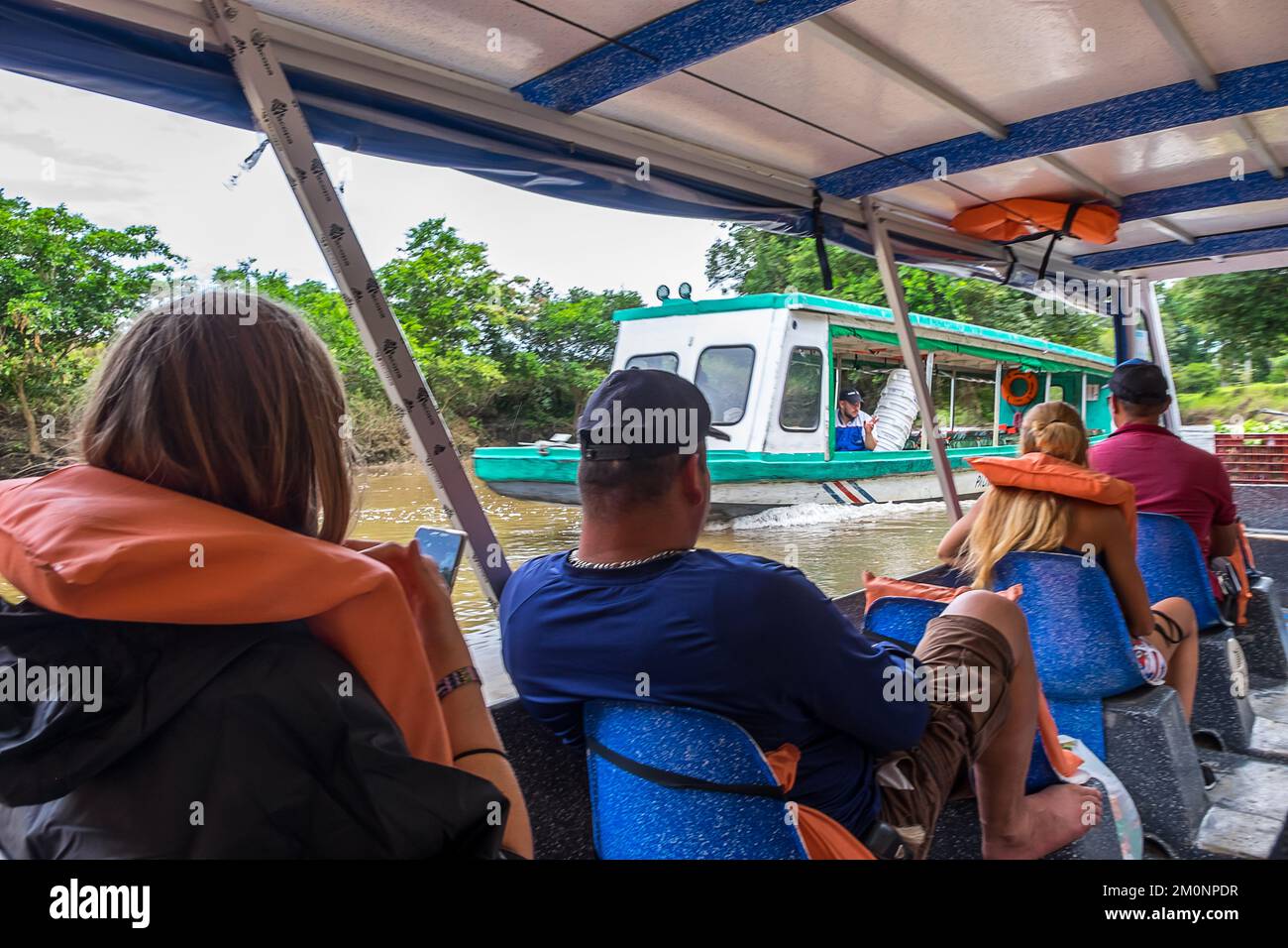 Persone a bordo di barche fluviali che navigano attraverso il canale di Tortuguero in Costa Rica Foto Stock