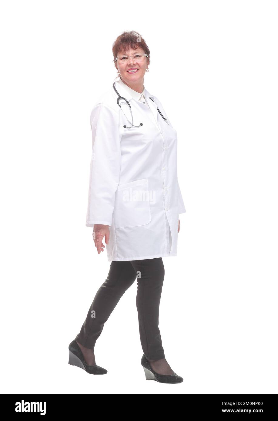Donna dottore che cammina verso la macchina fotografica sorridendo Foto Stock