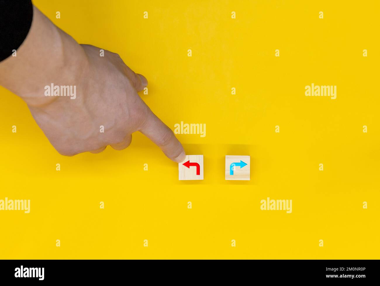 La mano che seleziona sinistra tra i blocchi di legno contrassegnati con l'icona sinistra e destra Foto Stock