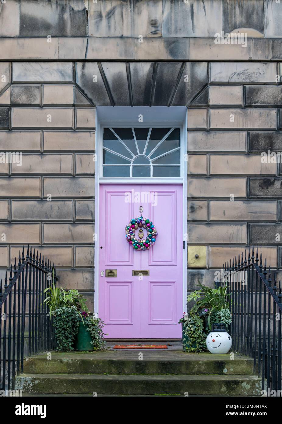 Fan della casa cittadina georgiana e porta d'ingresso rosa con corona di Natale, Drummond Place, Edinburgh New Town, Scozia, Regno Unito Foto Stock