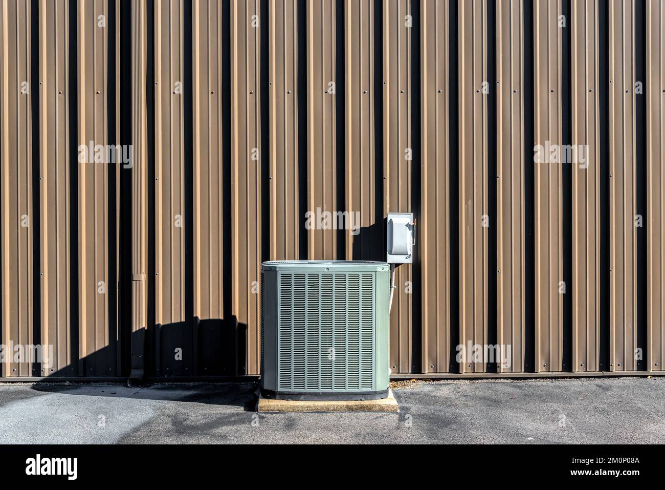 Immagine orizzontale di un compressore A/C davanti a una parete marrone vuota con spazio per le copie. Foto Stock