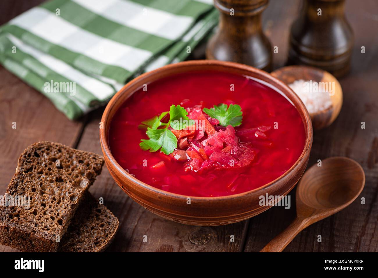 Minestra di borscht senza carne servita con pane di segale su sfondo tavolo di legno, cibo di cultura ucraina Foto Stock