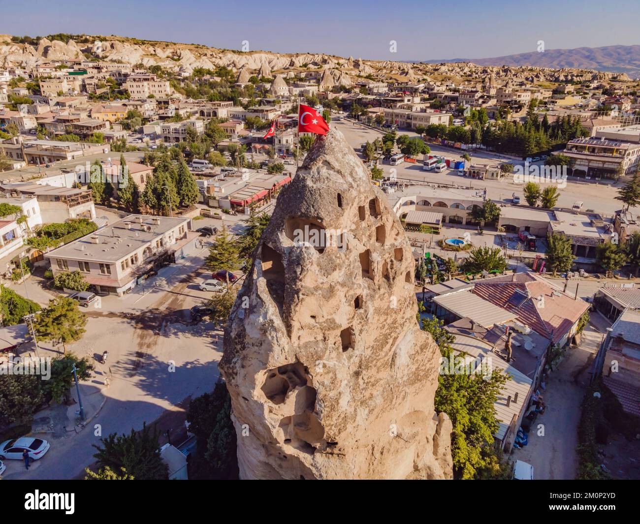 Bandiera turca sulla collina con tipiche formazioni rocciose di tufo della Cappadocia sullo sfondo di un cielo blu, Goreme, Turchia Foto Stock