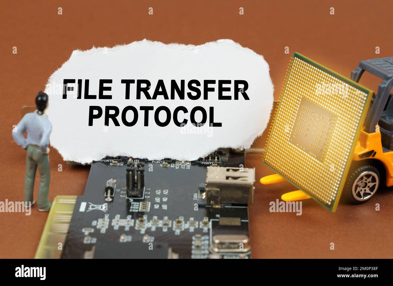 Concetto di computer. Sulla scheda con microcircuiti si trova una lastra di carta con l'iscrizione - file Transfer Protocol. Nelle vicinanze si trova un caricatore di giocattoli con un proc Foto Stock