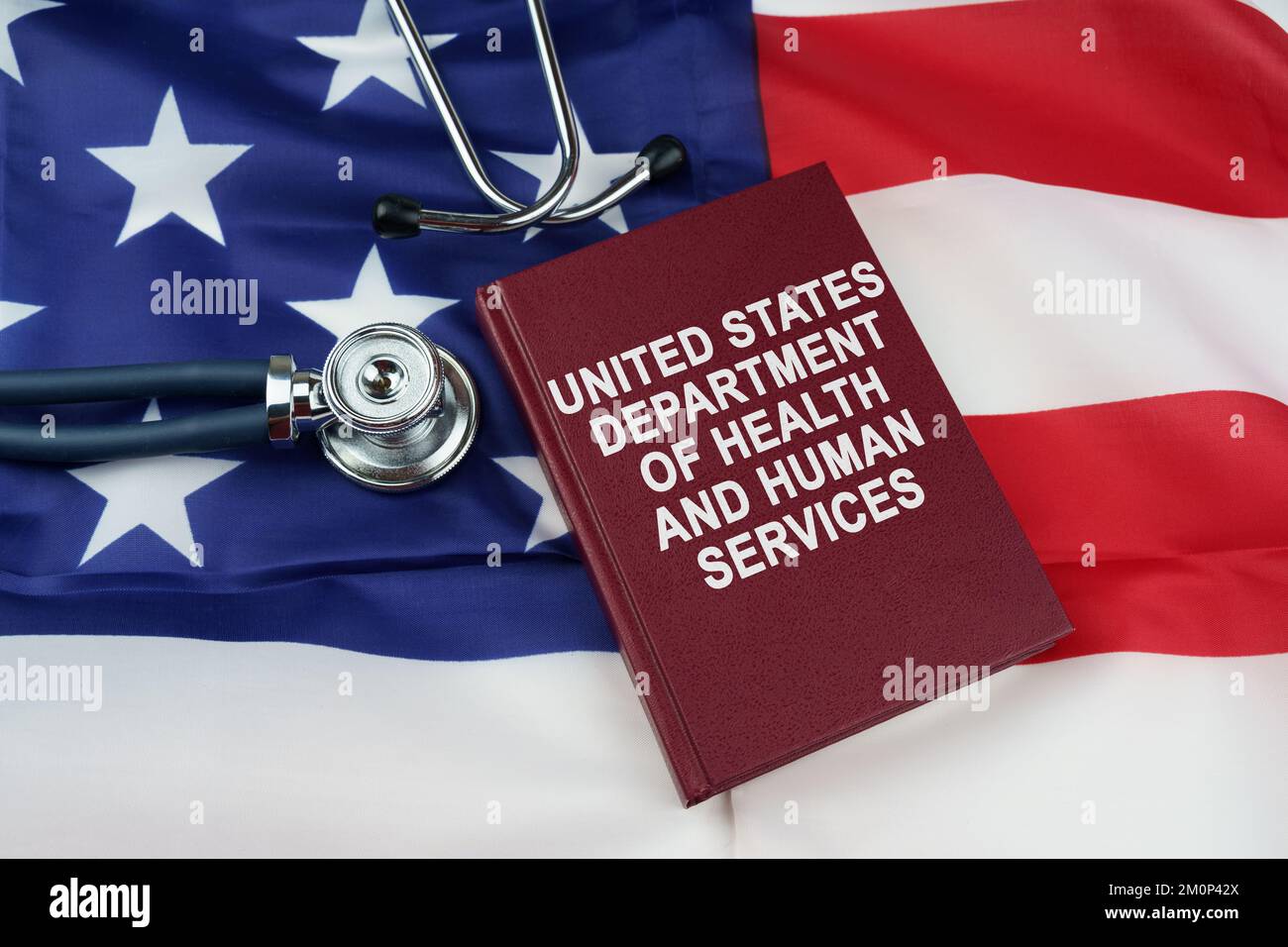 Concetto di legge. Sulla bandiera degli Stati Uniti si trova uno stetoscopio e un libro con l'iscrizione - United States Department of Health and Human Services Foto Stock