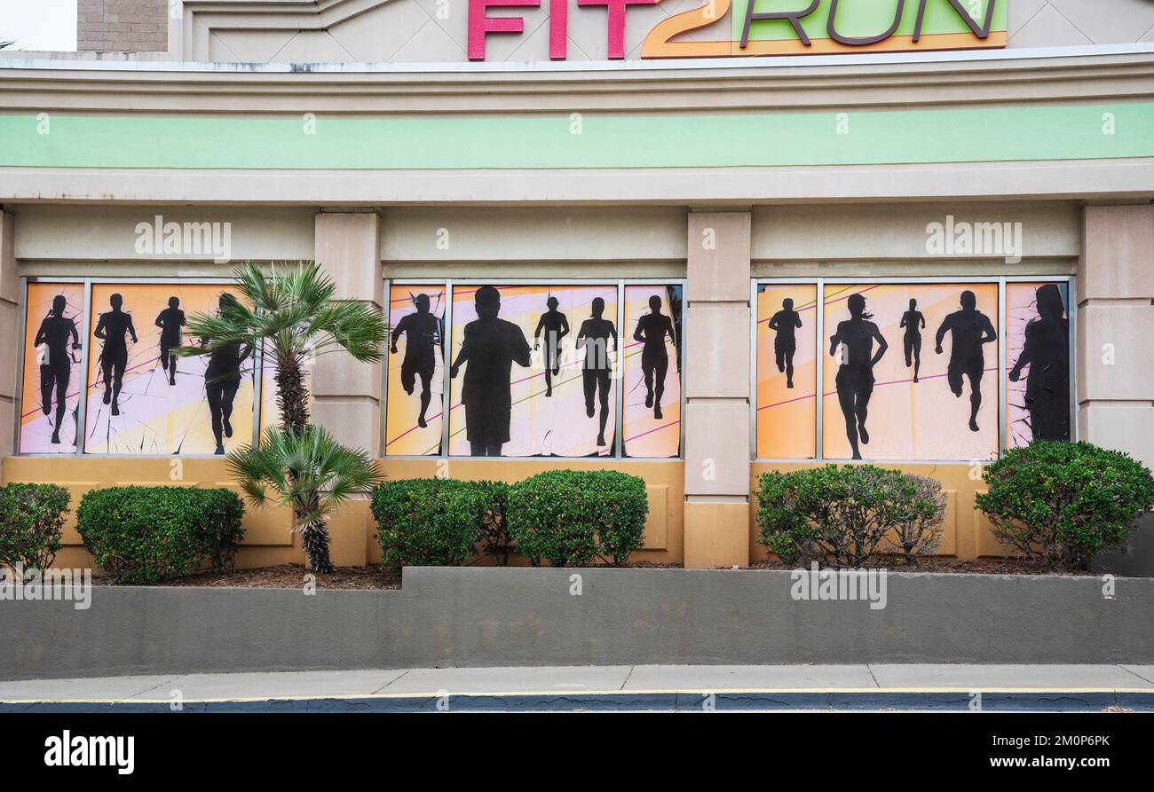 Murale di corridori in silhouette grazia l'esterno di FIT 2 RUN, centro di allenamento fitness in un centro commerciale Florida. Foto Stock