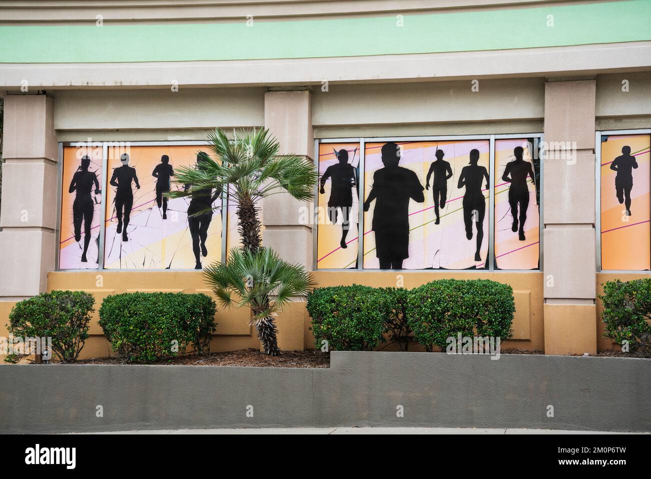 Murale di corridori in silhouette grazia l'esterno di FIT 2 RUN, centro di allenamento fitness in un centro commerciale Florida. Foto Stock