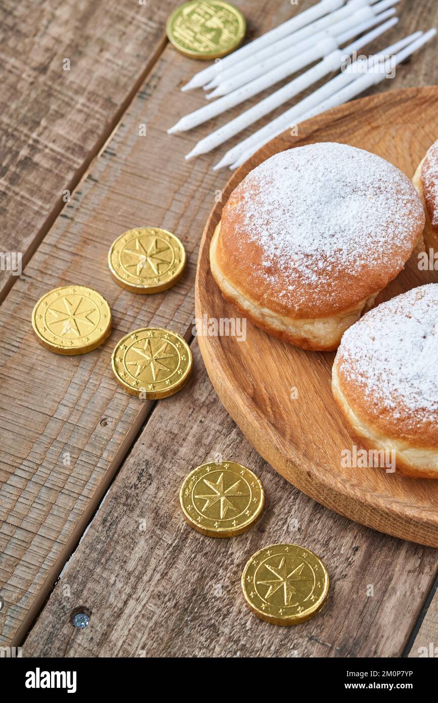 Hanukkah felice. Ciambelle dolci Hanukkah, scatole regalo, candele bianche e monete di cioccolato su vecchio sfondo di legno. Immagine e concetto di vacanza ebraica Foto Stock